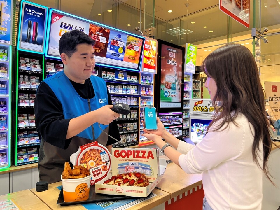 GS25에서 모델이 퀵커머스 특화 상품 라인업 3종을 결제하고 있다. / 사진=GS리테일