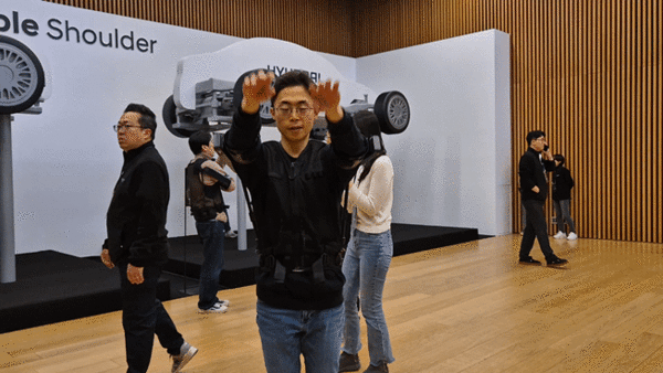 엑스블 숄더를 입고 양팔을 휘두르는 동작을 시연하고 있다. / 영상=최동훈 기자