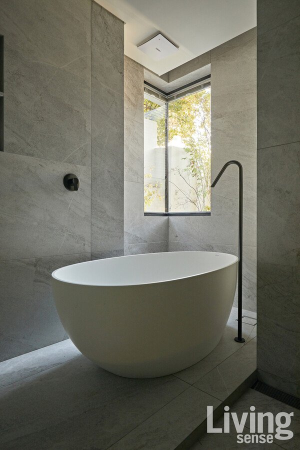 목욕을 즐기는 부부를 위해 깊고 큰 욕조를 배치한 욕실. 창 너머로 보이는 정원의 풍경이 평화로움을 자아낸다.