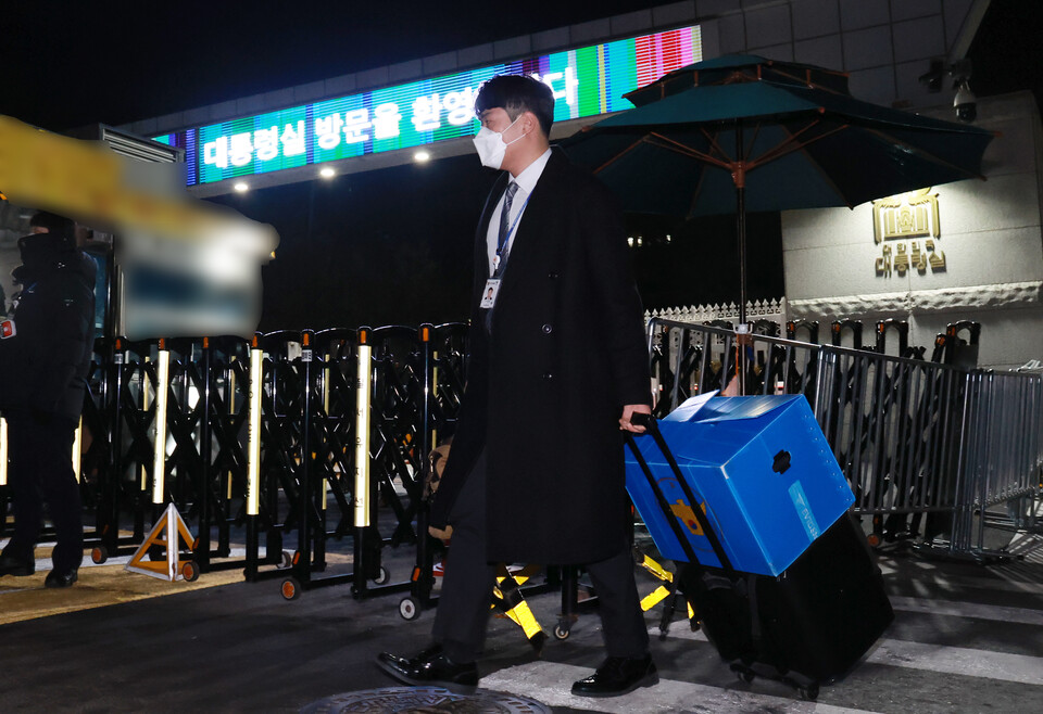 대통령실 압수수색에 나선 경찰 국가수사본부(국수본) 관계자들이 11일 저녁 서울 용산 대통령실 민원실을 나서며 압수물 박스와 포렌식 장비를 옮기고 있다. / 사진=연합뉴스