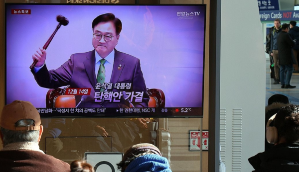 지난 15일 서울역 대합실에서 시민들이 대통령 탄핵소추안 가결 관련 뉴스를 시청하는 모습. / 사진=연합뉴스