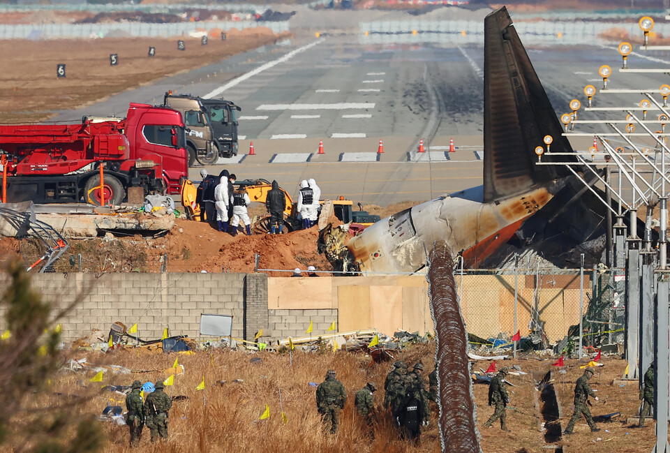 3일 오전 전남 무안군 무안국제공항 제주항공 여객기 참사 현장에서 항공철도사고조사위원회 및 국과수 관계자 등이 방위각시설(로컬라이저)에 파묻힌 엔진을 살펴보고 있다. / 사진=연합뉴스