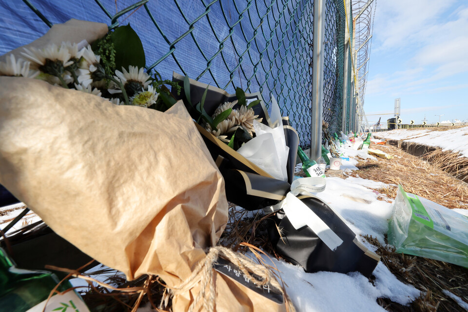 10일 낮 전남 무안군 무안국제공항 제주항공 여객기 참사 현장 인근 철조망에 추모객이 두고 국화 꽃다발이 놓여있다. / 사진=연합뉴스