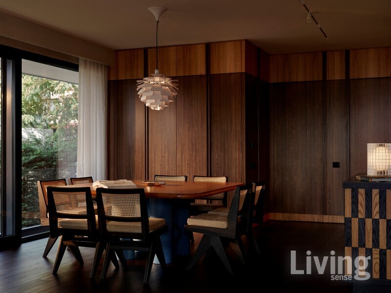 목재로 빈티지 미학을 강조한 다이닝 룸. 벽에는 저장 공간 뿐 아니라 주방 및 게스트 화장실로 통하는 문도 숨겨져 있다.