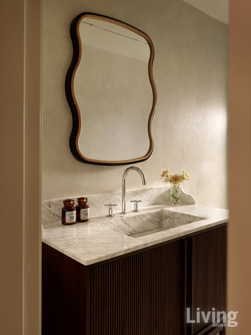 유동적 형태의 거울과 대리석으로 고요함 속 생동감을 높인 욕실.