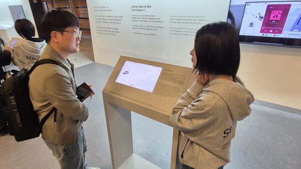 플레오스 참가자들이 개발자용 개발 장치 데브박스를 시연하며 관계자와 소통하고 있다. / 사진=최동훈 기자