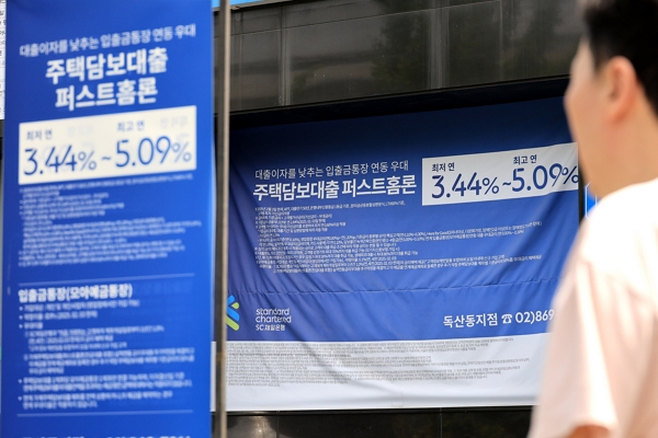 한 시민이 서울 시내 은행 앞 대출 홍보물을 지나고 있다. / 사진=연합뉴스