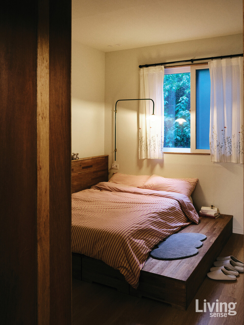 1층의 게스트 룸. 손수 제작한 나무 침대 프레임과, 은은한 조명이 어우러져 손님을 위한 따뜻한 공간이 된다.