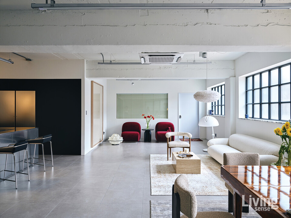 라운지 체어, 소파, 커피 테이블, 다이닝 테이블 등유기적인 가구 구성이 돋보이는 거실.