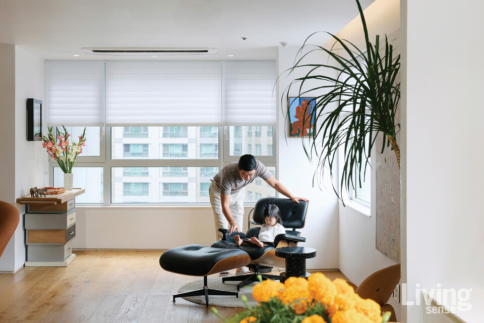 딸에게 책을 읽어주는 장준용 씨. 딸 단이가 앉아 있는 의자는 허먼 밀러Herman Miller의 임스 라운지체어와 오토만.