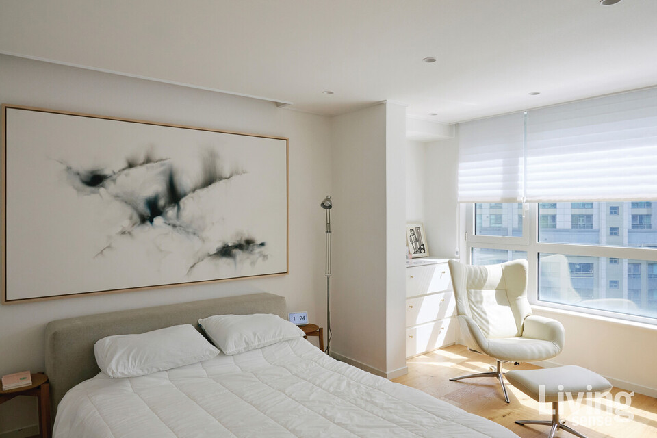 깔끔한 화이트 톤으로 꾸민 부부 침실에는 장 보고시안Jean Boghossian의 작품과 케베KEBE폭스Fox 리클라이너 체어가 자리한다.