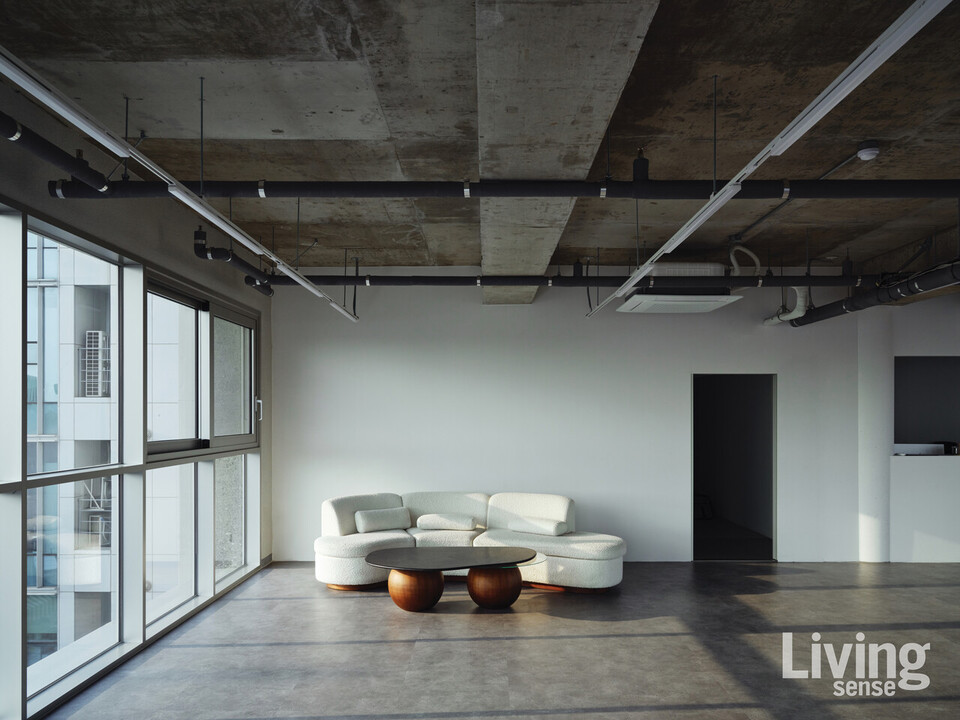 6층 전시장 한켠에 자리한 이스턴에디션의 커브드 소파와 그라운드 티 테이블. 낮부터 해 질 녘, 그리고 어둠이 내려앉은 뒤까지 전시를 감상하기에 제격인 자리다.