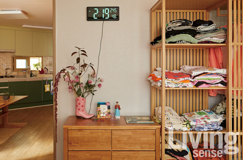 채도가 밝은 원목 소재로 지어진 계단과 톤을 통일한 가구들. 컬러풀한 옷들과 소품도 눈에 띈다.