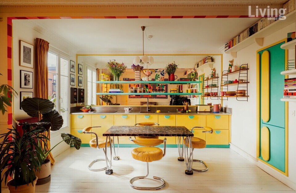거실에서 바라본 주방의 모습. 컬러, 형태, 소재 플레이로 그래픽적이면서도 편안함이 감돈다. 공간의 한가운데를 차지한 시티 테이블과 코브라 체어는 부부가 집에서 가장 아끼는 가구다.